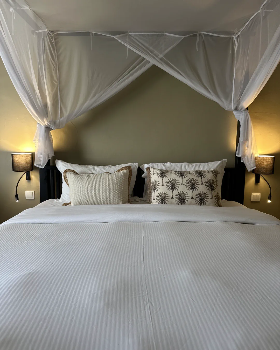 Chambre Bali, lit à baldaquin en bois sous moustiquaire déployée, hôtel O Mamma Mia à Lourmarin
