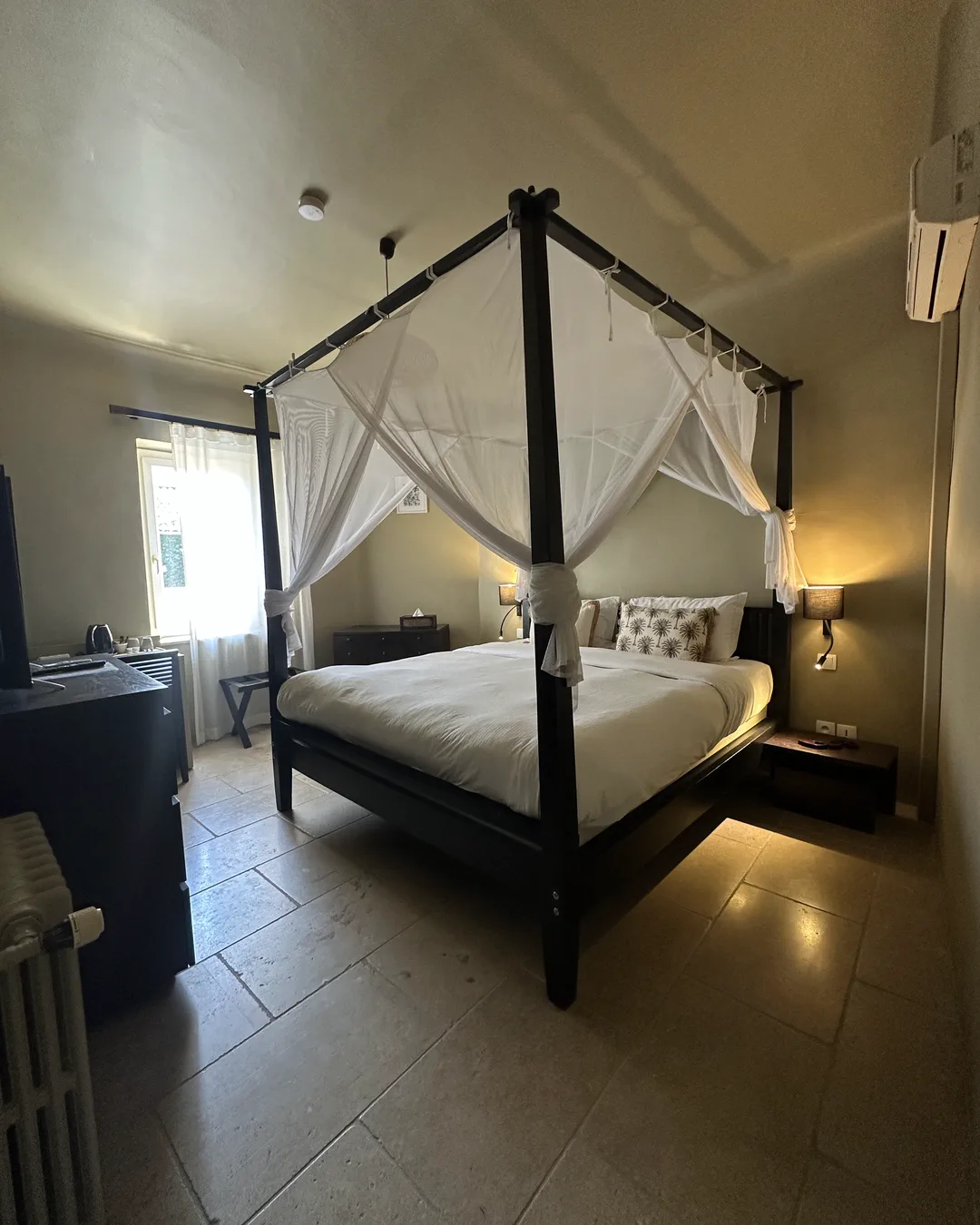 Vue d'ensemble de la chambre Bali, lit à baldaquin et sol en pierre claire, hôtel O Mamma Mia, Lourmarin
