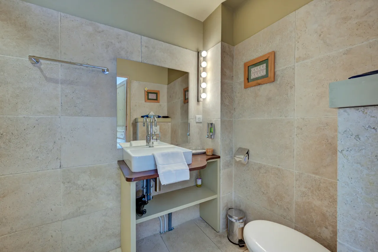 Vasque, miroir à ampoules et WC de la salle de bains privative, chambre Capri, Lourmarin