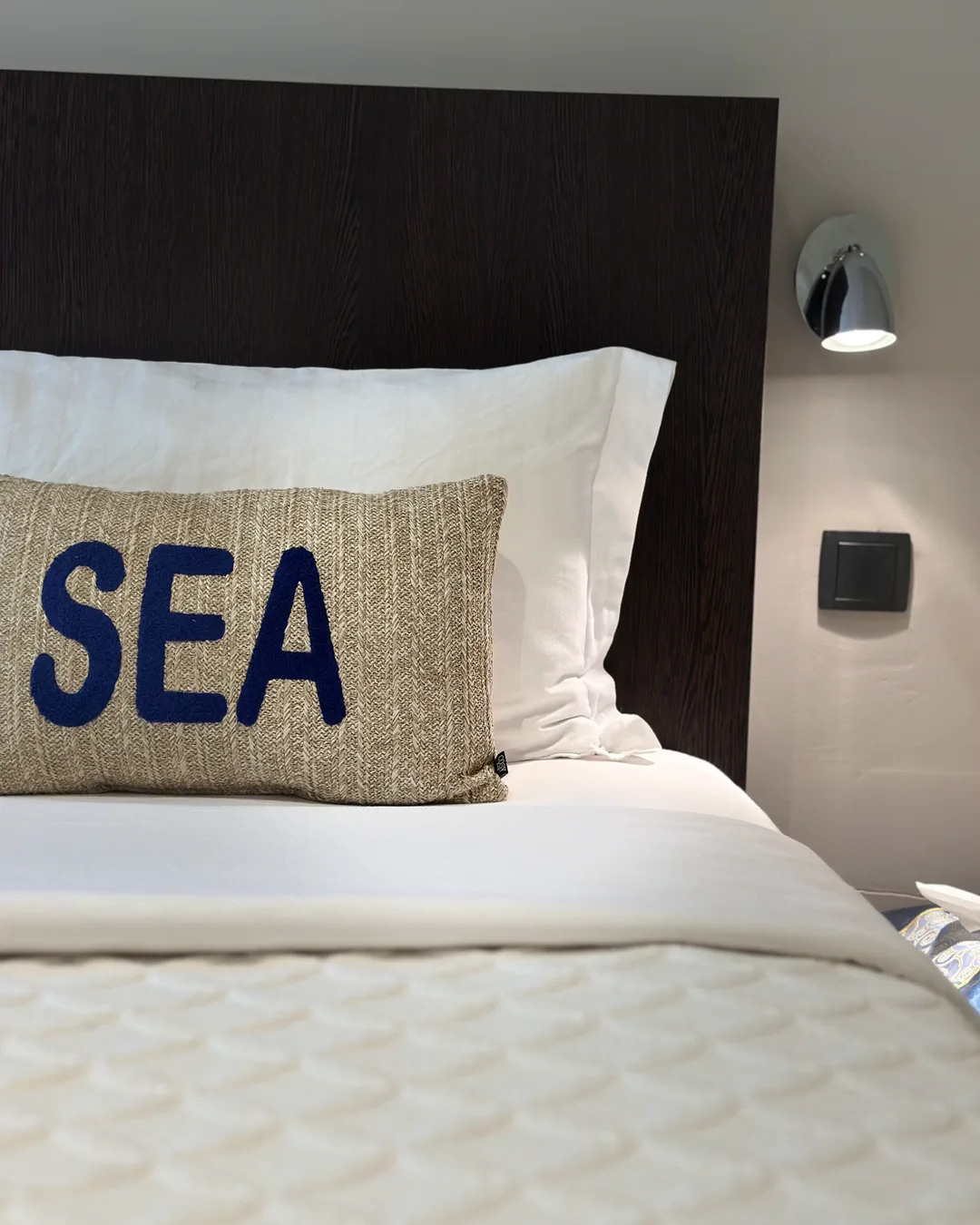 Coussin « Sea » posé sur la tête de lit en bois foncé, chambre Venezia, hôtel O Mamma Mia, Lourmarin