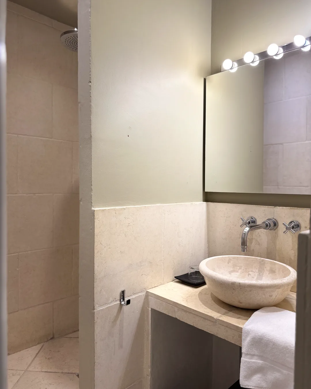Vasque, miroir à ampoules et douche à l'italienne, salle de bains de la chambre Hanoï, Lourmarin