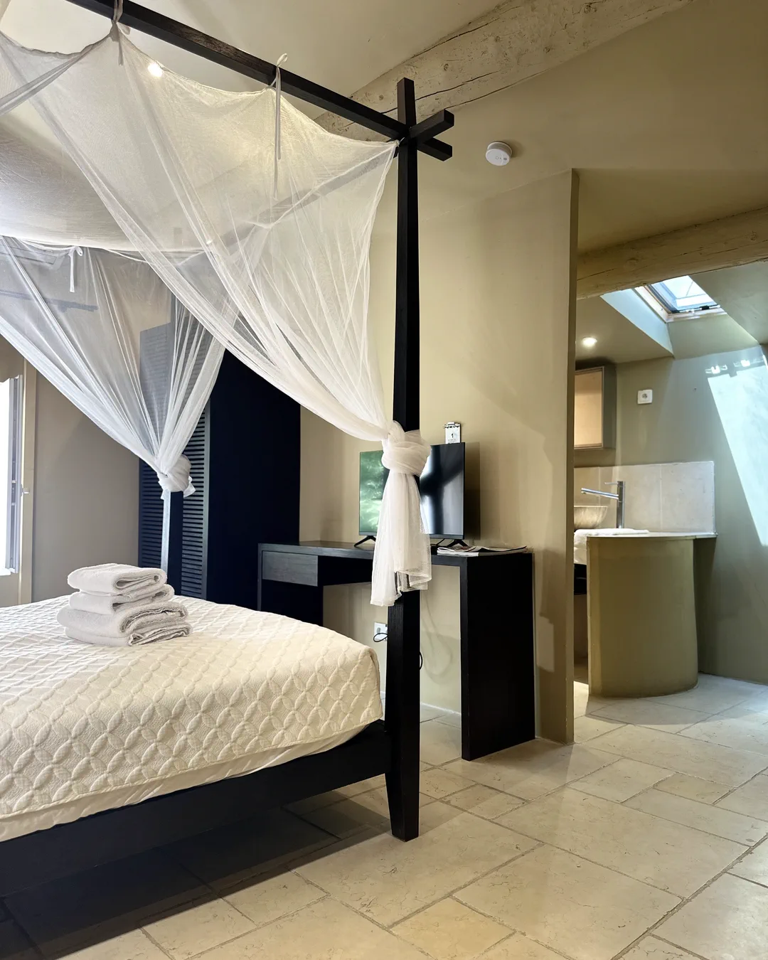 Coin nuit et accès à la salle de bains sous les poutres, chambre Shangaï, Lourmarin