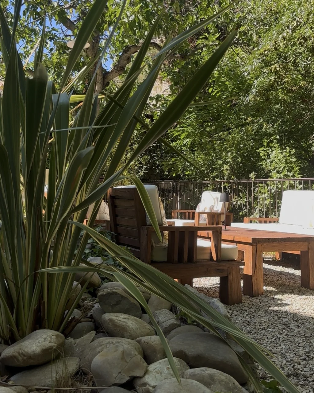 Salon d'extérieur en bois et coussins clairs au bord du jardin, hôtel O Mamma Mia à Lourmarin