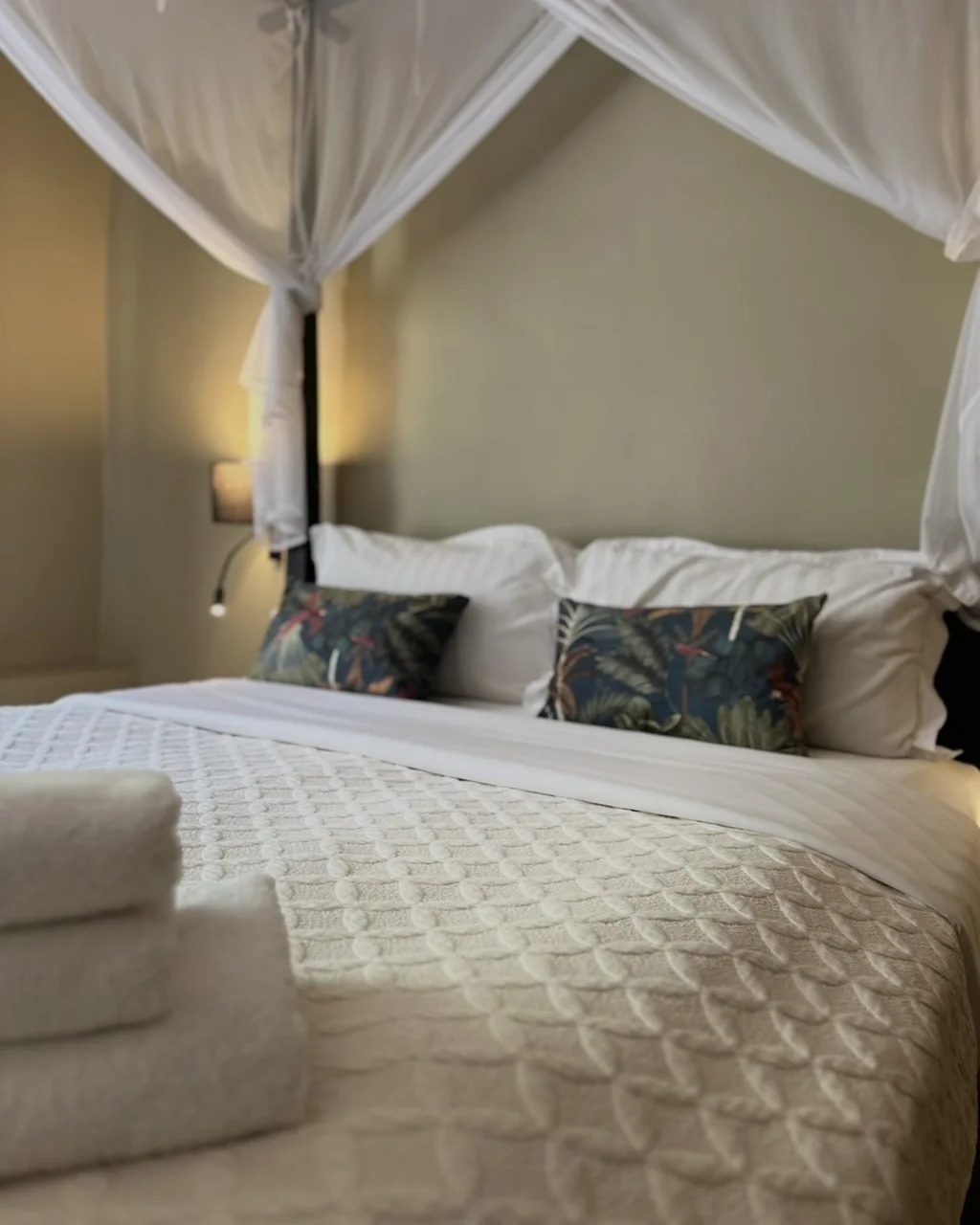 Lit à baldaquin sous moustiquaire, coussins tropicaux et serviettes de bain, hôtel O Mamma Mia à Lourmarin