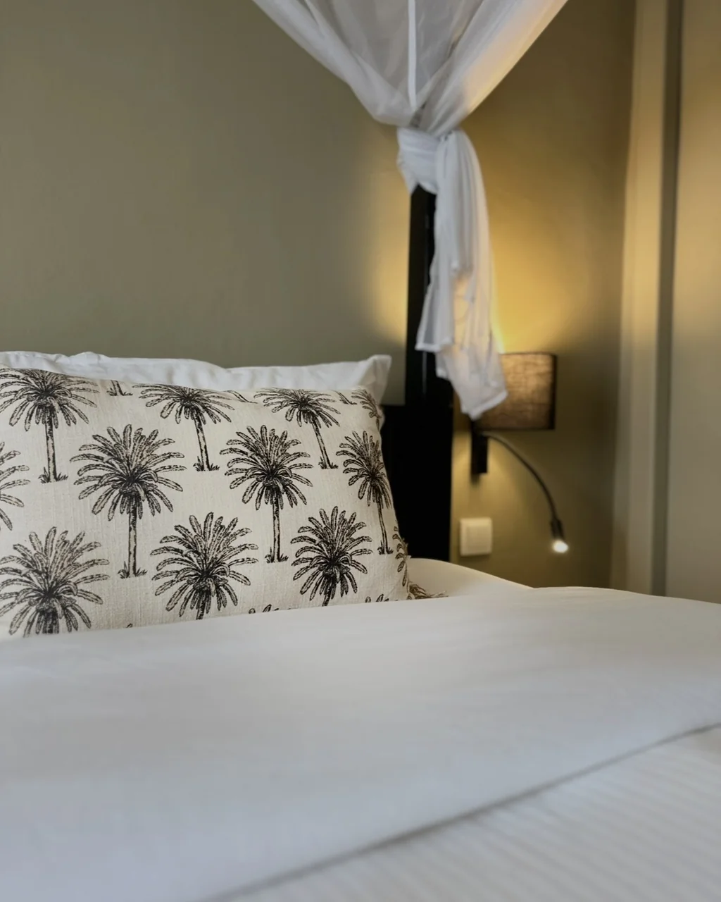 Coussin à motif de palmiers sur le lit à baldaquin, hôtel O Mamma Mia à Lourmarin