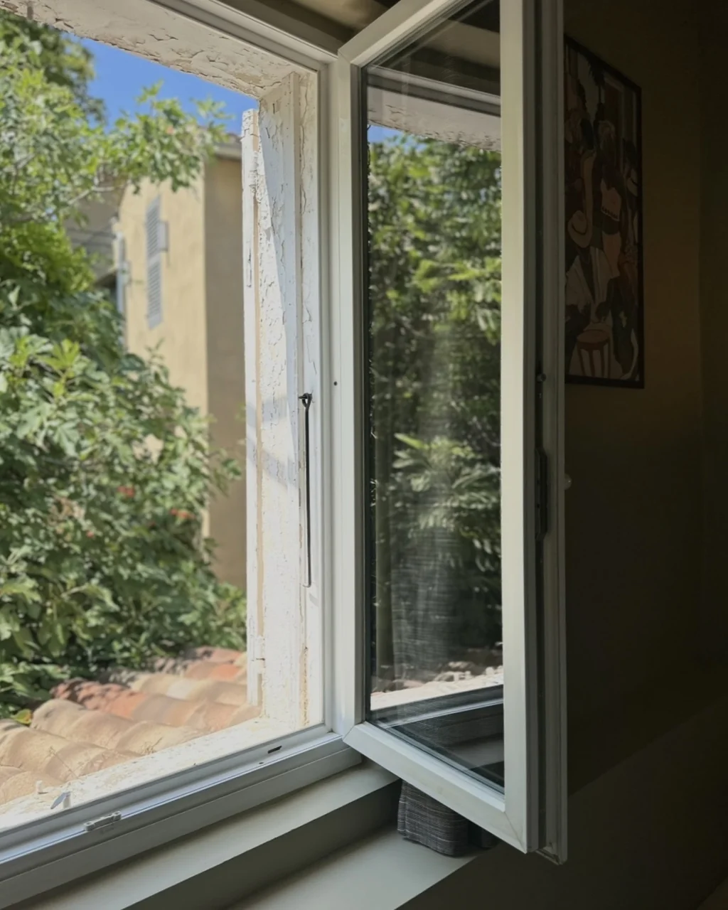Fenêtre ouverte sur la végétation du parc depuis une chambre, hôtel O Mamma Mia à Lourmarin