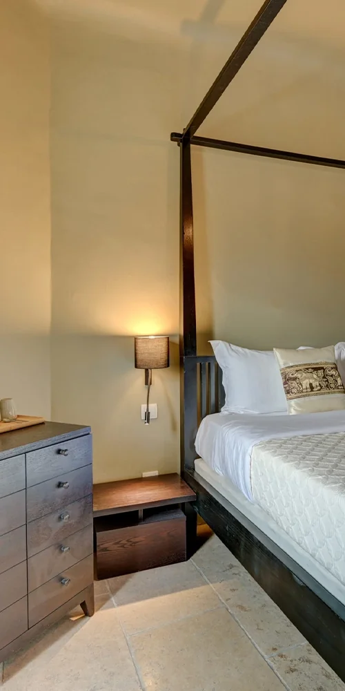 Coin d'une chambre, lit à baldaquin, applique et commode, hôtel O Mamma Mia à Lourmarin