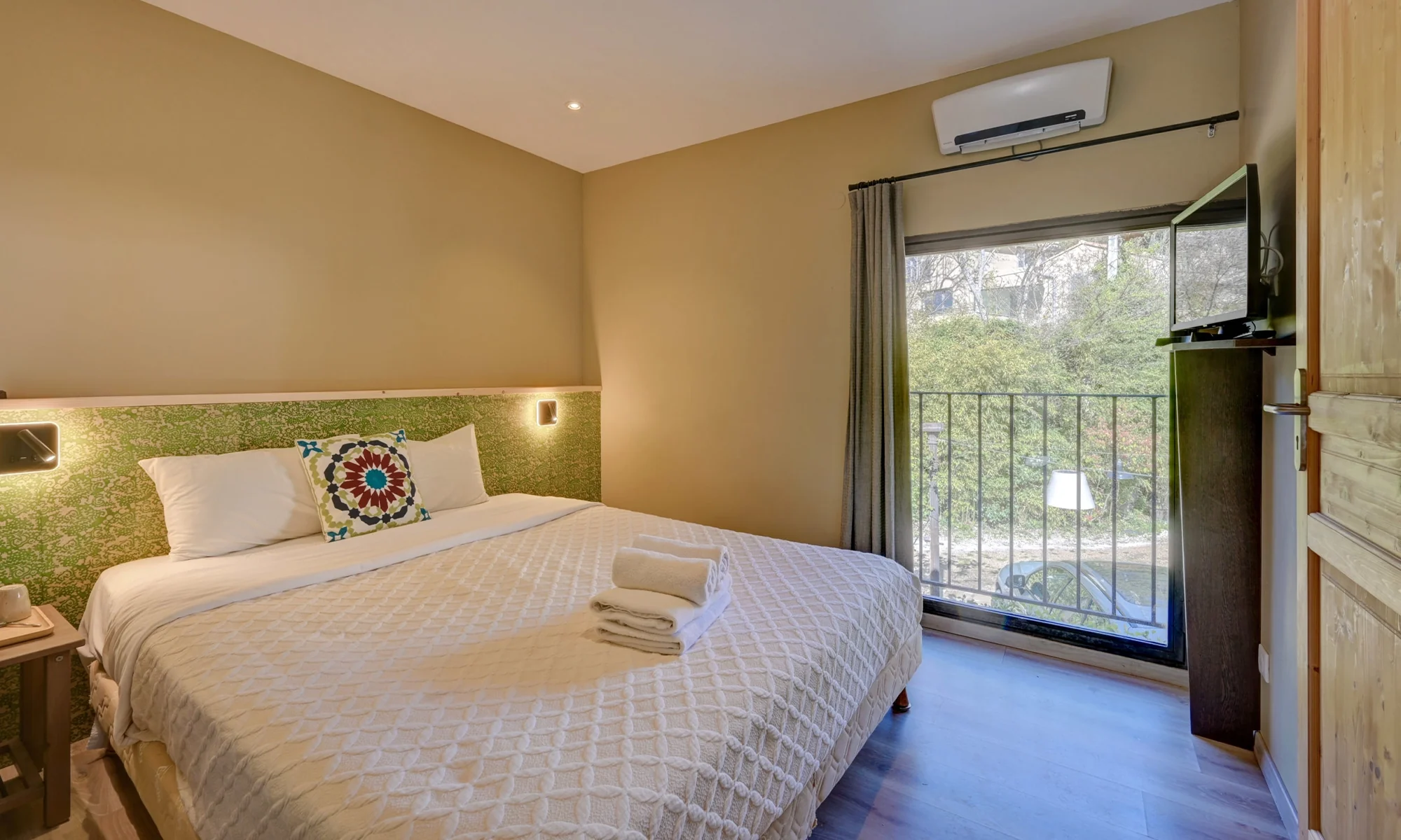 Chambre verte avec balcon donnant sur la végétation, hôtel O Mamma Mia à Lourmarin