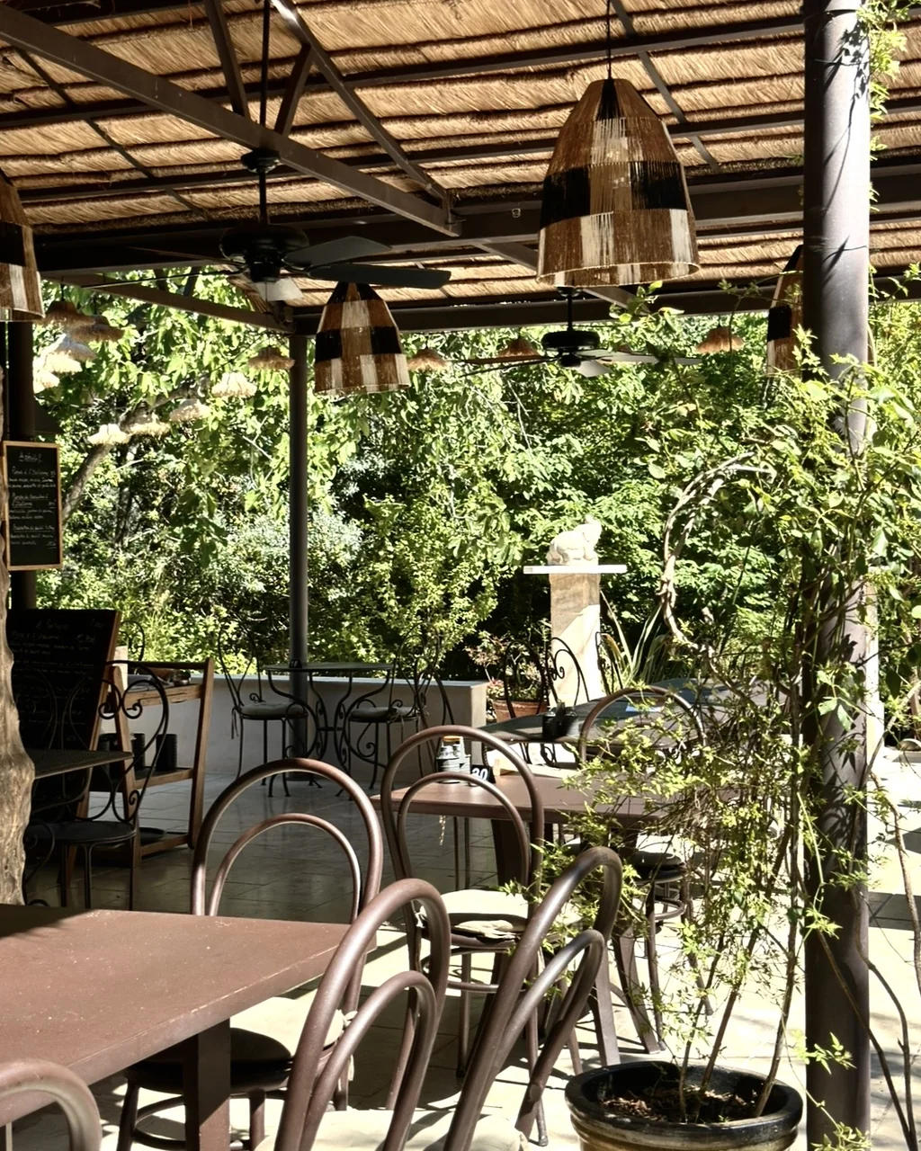Terrasse couverte d'un toit de roseaux, suspensions en rotin et ardoises du jour, restaurant O Mamma Mia à Lourmarin