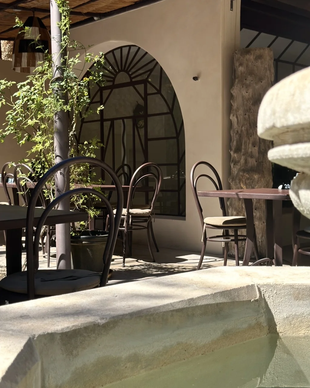 Arche en fer forgé et bassin de la fontaine sur la terrasse, restaurant O Mamma Mia à Lourmarin