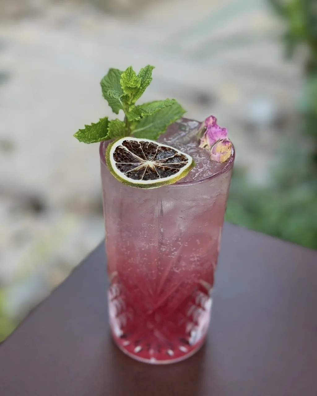 Cocktail rose à la menthe et au bouton de rose dans un verre ciselé, bar O Mamma Mia à Lourmarin