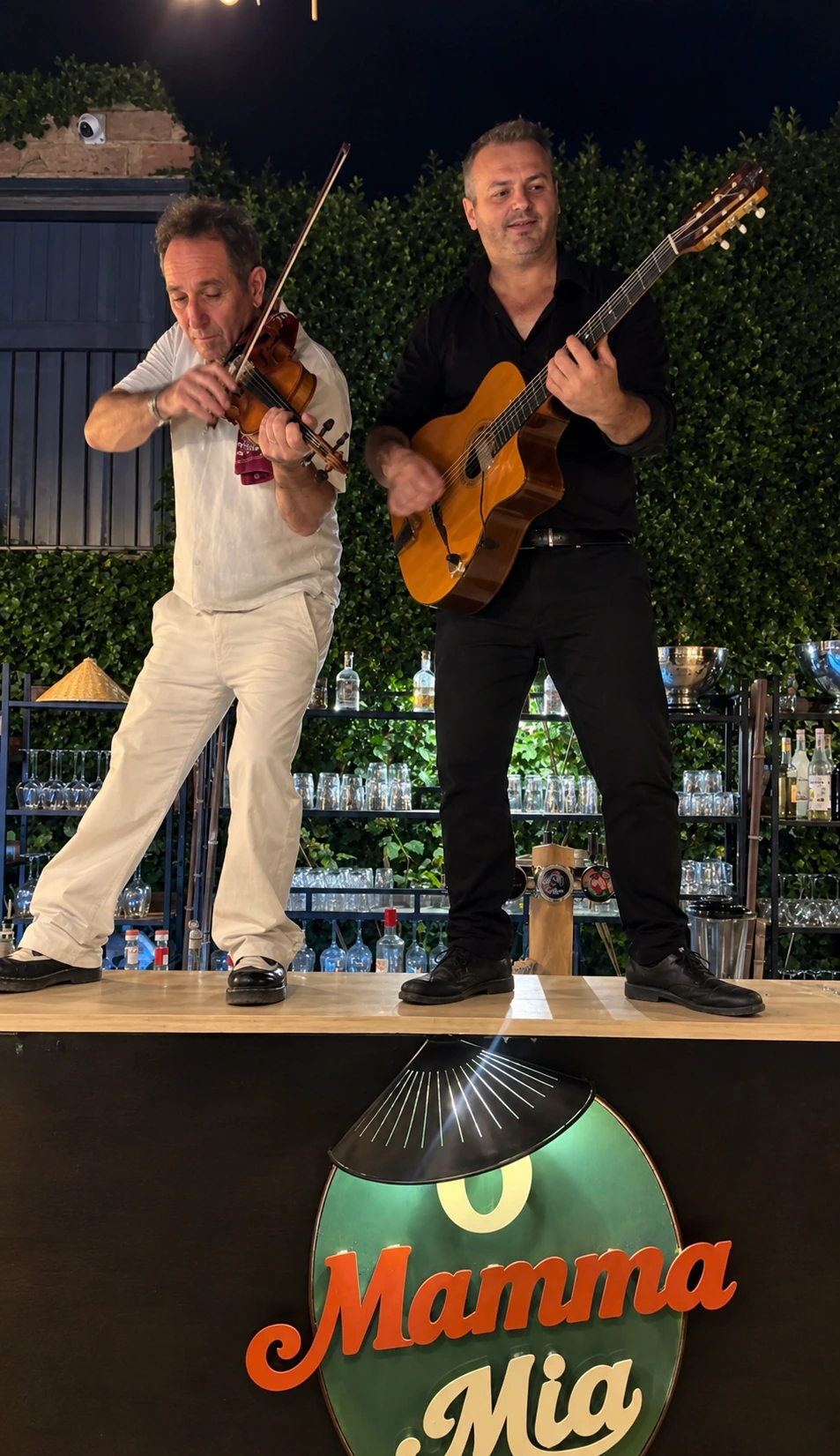 Duo violon et guitare jouant sur le bar, sous l'enseigne O Mamma Mia, soirée O Mamma Live à Lourmarin